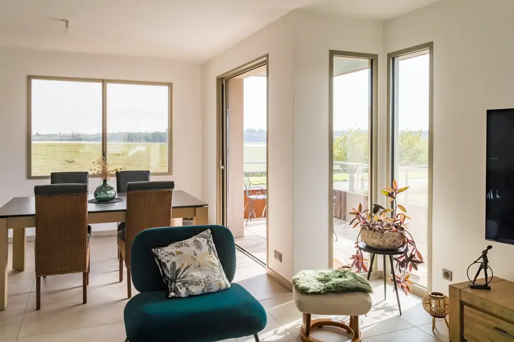 Baie vitrée coulissante en aluminium et fenêtres fixes, apportant une grande luminosité au salon et salle à manger d'une maison moderne à Pau