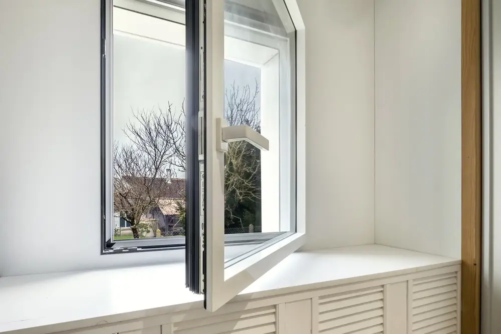 Fenêtre oscillo-battante en aluminium blanc, vue intérieure avec appui de fenêtre, installée pour un confort optimal à Pau