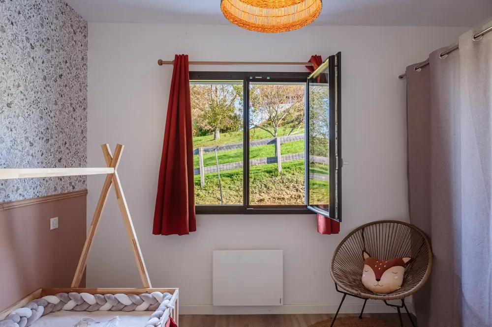 Fenêtre en aluminium noir, oscillo-battante pour la sécurité et la ventilation de la chambre d'enfant, avec vue sur le jardin à Pau