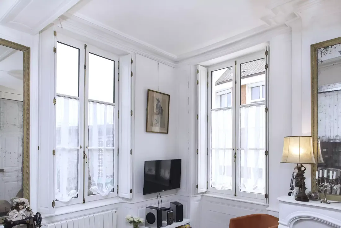 Deux fenêtres en bois blanc à la française, avec moulures et volets intérieurs, intégrées dans la rénovation d'un salon de style ancien à Pau