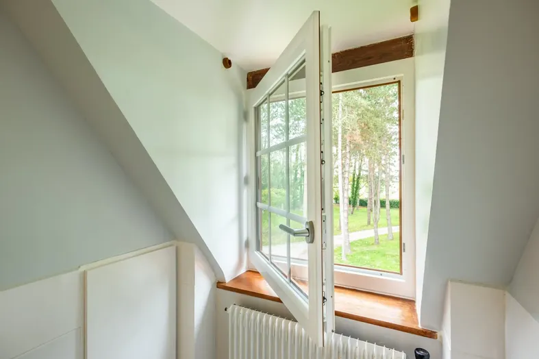 Fenêtre lucarne PVC blanche à simple vantail dans un comble aménagé à Pau