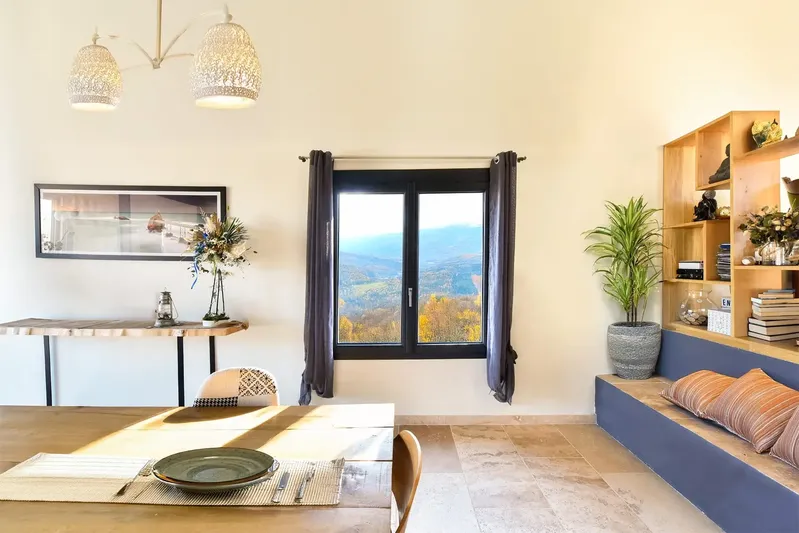 Fenêtre PVC double vantaux noire dans une salle à manger avec vue sur les montagnes des Pyrénées