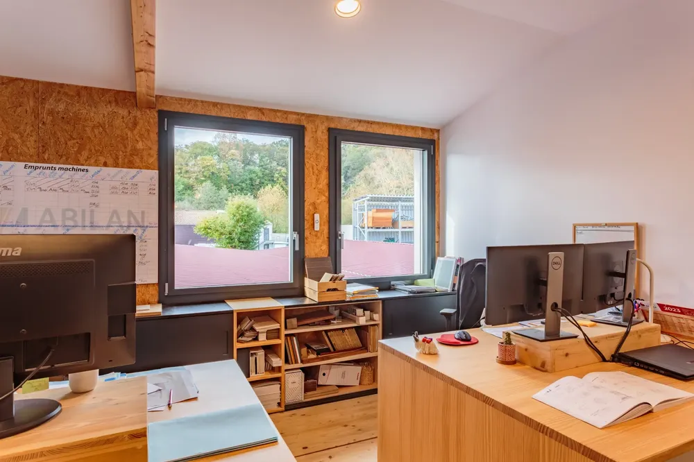 Deux fenêtres en aluminium noir dans un bureau professionnel, offrant une excellente luminosité et ventilation pour un espace de travail à Pau