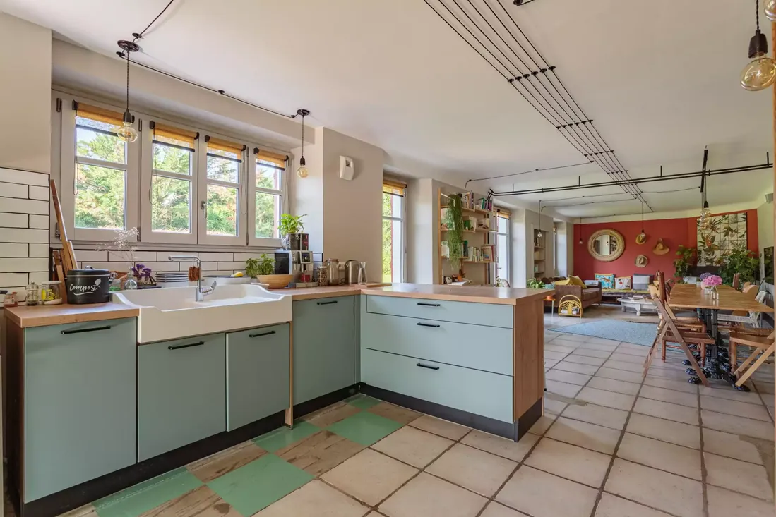 Fenêtres en bois de couleur blanc dans une grande cuisine ouverte sur un salon, apportant luminosité à cet espace de vie moderne