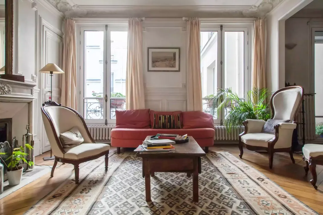 Fenêtres en bois blanc à double battant, intégrées dans un salon de style haussmannien rénové avec moulures au plafond au centre historique de Pau
