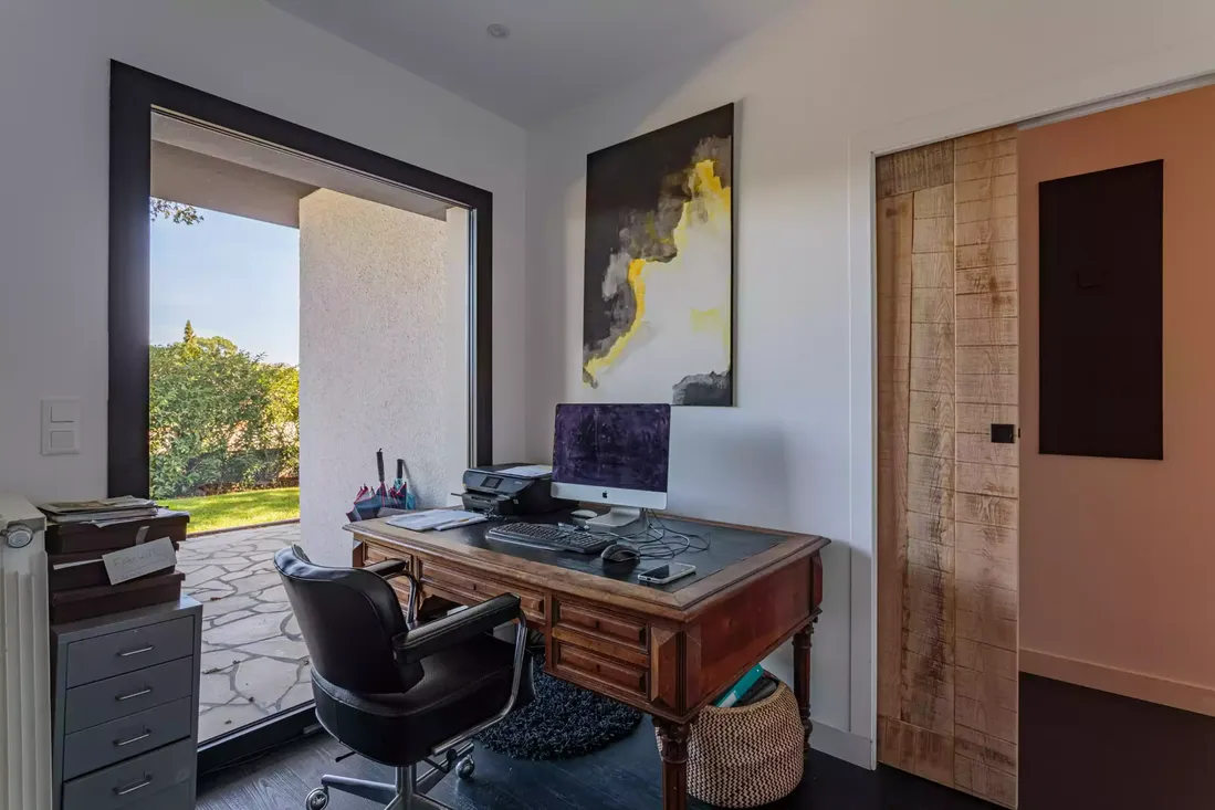Porte-fenêtre en aluminium noir ouvrant sur le jardin dans un bureau à domicile, optimisant la lumière naturelle et l'accès extérieur à Pau