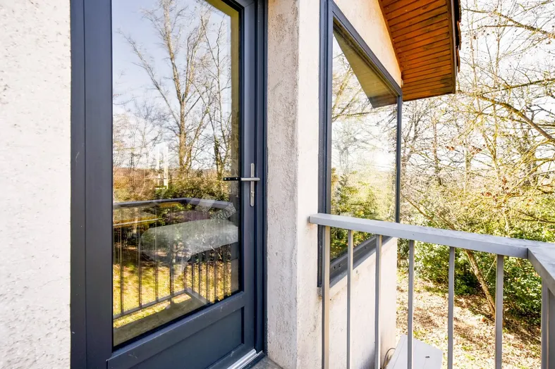 Porte-fenêtre en aluminium anthracite sur un balcon avec double vitrage