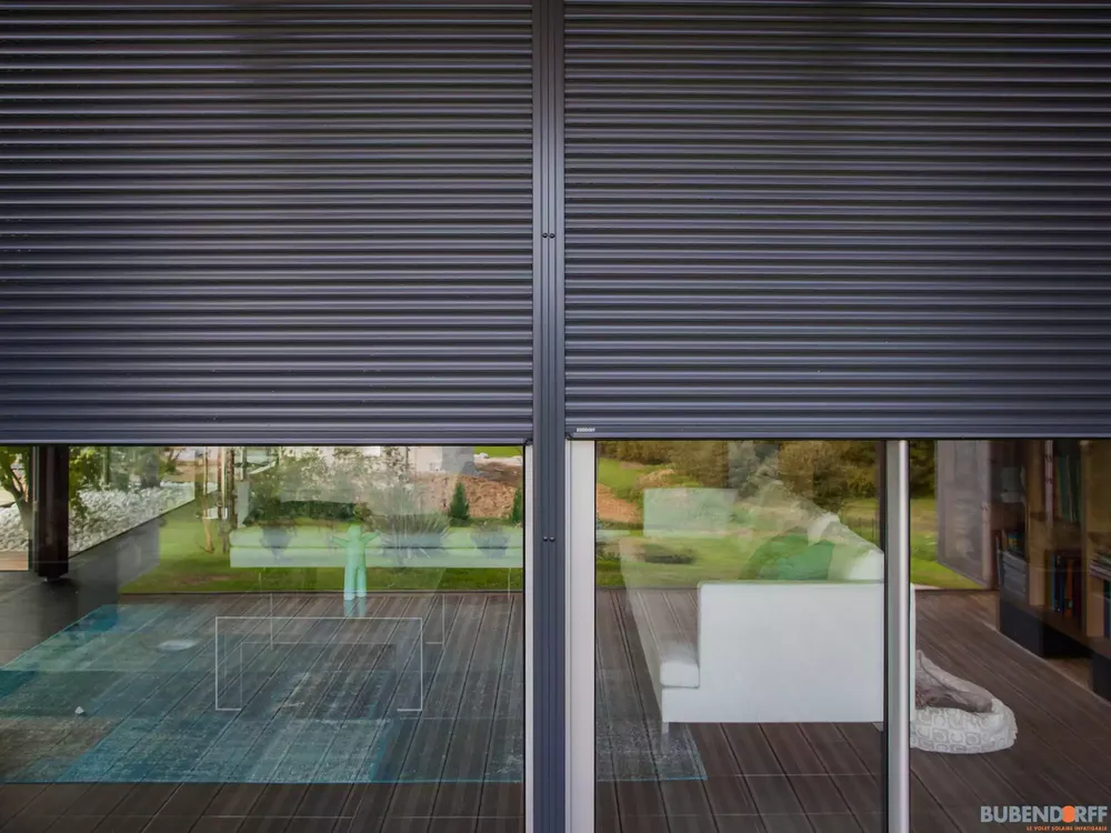 Double volet roulant électrique gris anthracite sur grande baie vitrée pour une maison contemporaine à Pau.