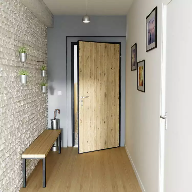 Porte blindée Picard à effet bois clair, pose dans un hall d'entrée moderne à Pau avec mur en briques de parement pour une sécurité et un design optimaux.