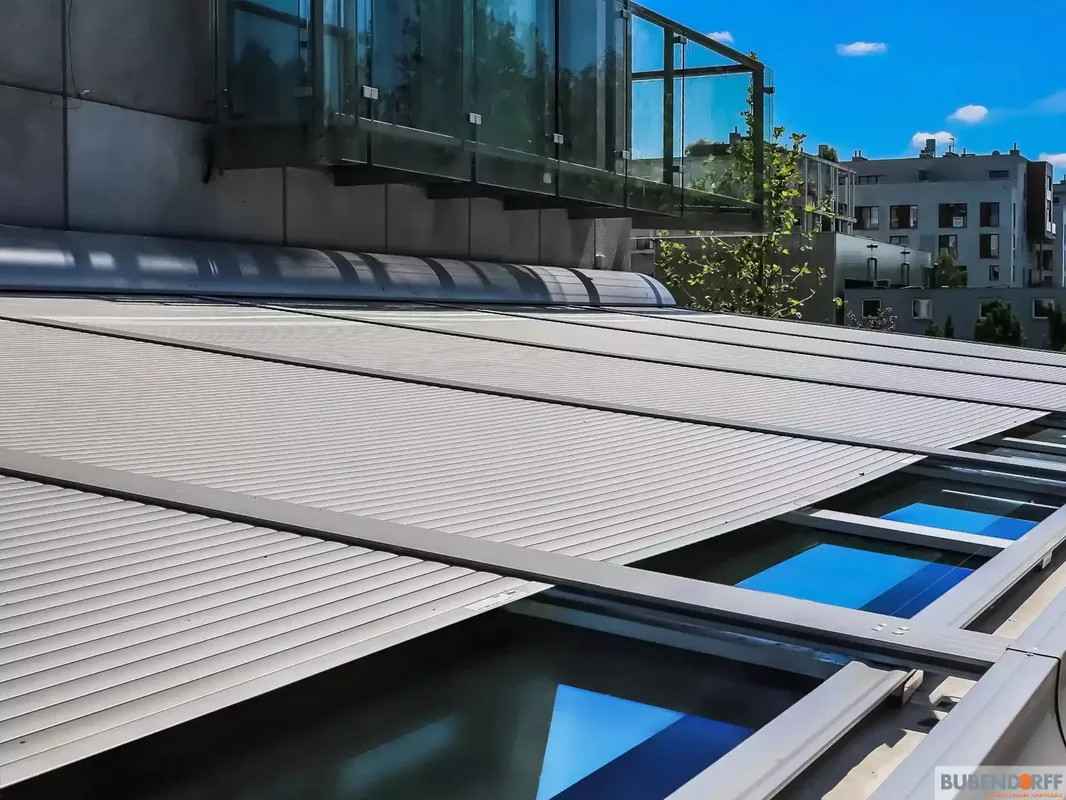Volet roulant horizontal Rolax en aluminium, installé sur la toiture vitrée d'une véranda moderne ou d'une terrasse au centre ville de Pau