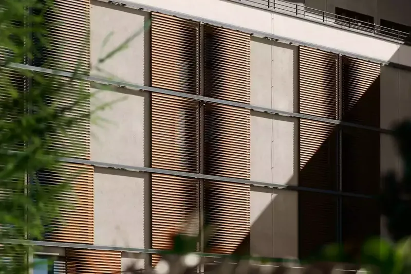 Volets persiennes extérieurs en bois sur façade d'immeuble moderne à Pau